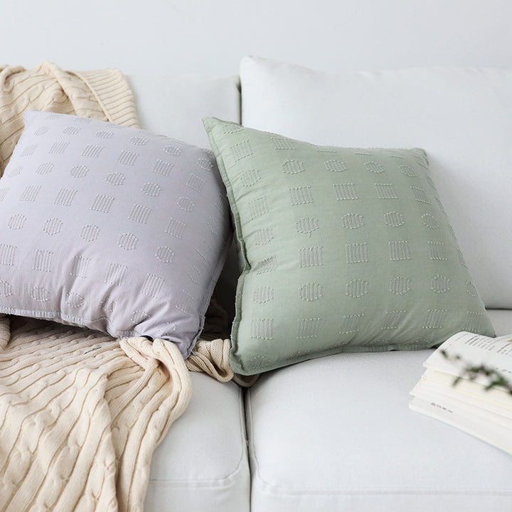 Square decorative cushion cover with subtle tufted geometric relief and piping