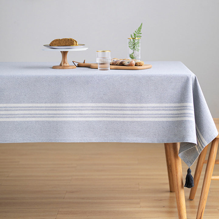 Rectangular tablecloth made of cotton-linen blend with subtle striped border and decorative tassels