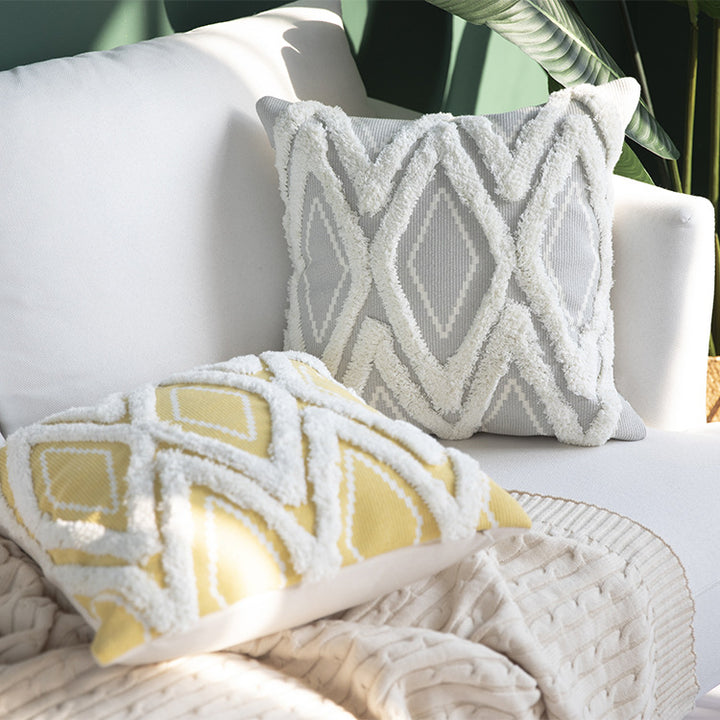 Decorative cushion cover with hand-tufted diamond relief and soft bouclé application