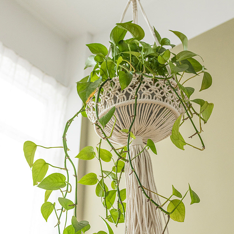 Macramé hanging planter with hand-knotted basket structure and decorative tassel