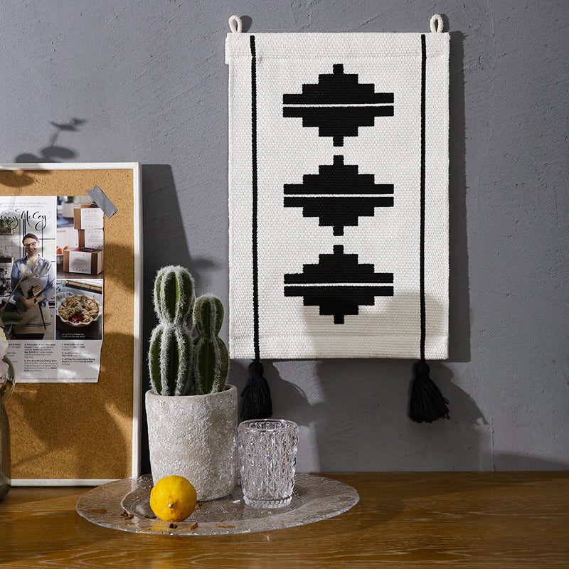 Woven wall hanging in minimalist geo pattern with decorative tassels and hanging loops
