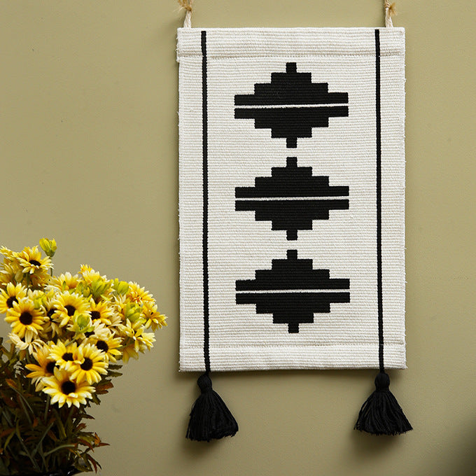 Woven wall hanging in minimalist geo pattern with decorative tassels and hanging loops