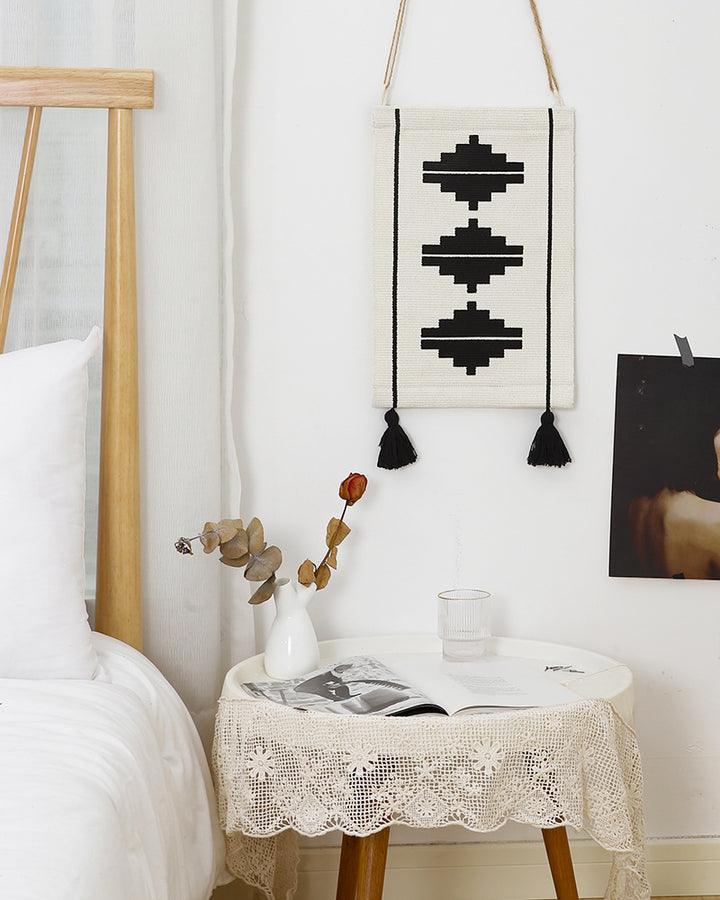 Woven wall hanging in minimalist geo pattern with decorative tassels and hanging loops