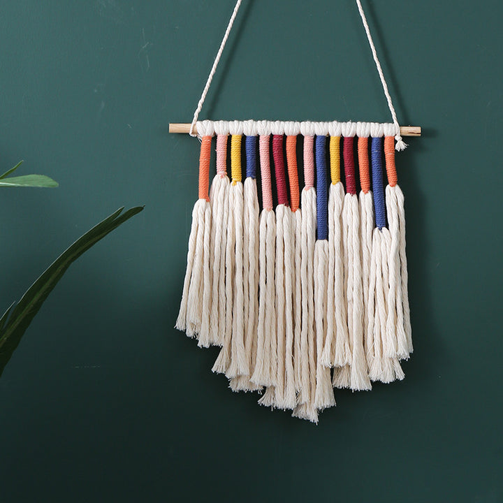 Handcrafted macrame wall hanging with colorful cotton fringes and wooden rod