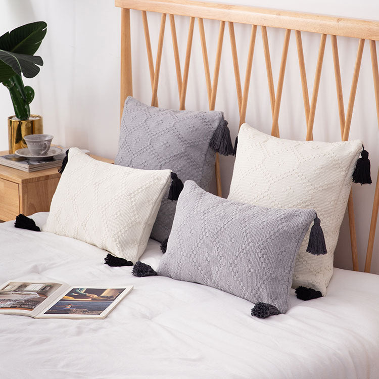 Decorative cushion cover made of woven cotton blend with tactile diamond structure and contrast tassels