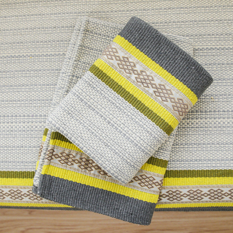 Handwoven table runner made of cotton blend with woven decorative border and striped texture