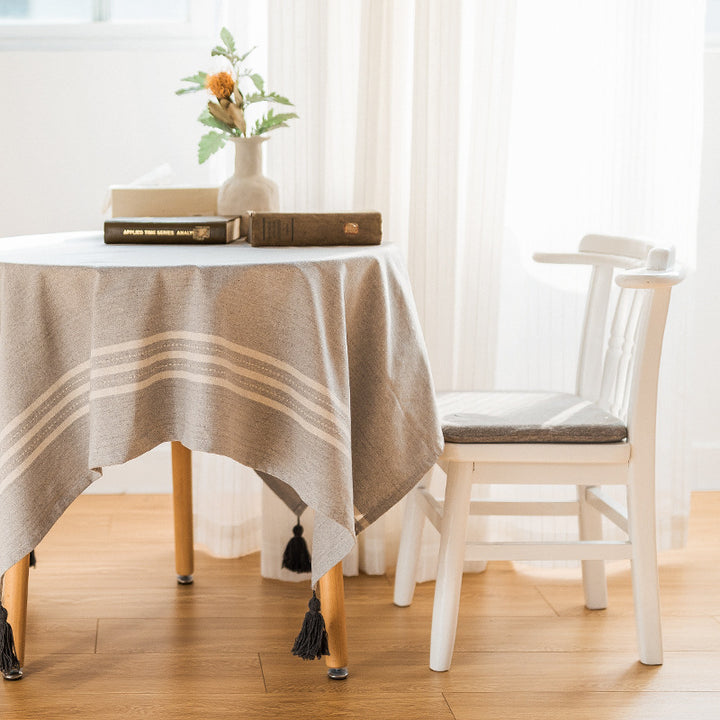 Rectangular tablecloth made of cotton-linen blend with subtle striped border and decorative tassels