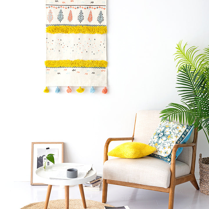 Woven wall hanging with tufted stripes, embroidered leaves, and tassels