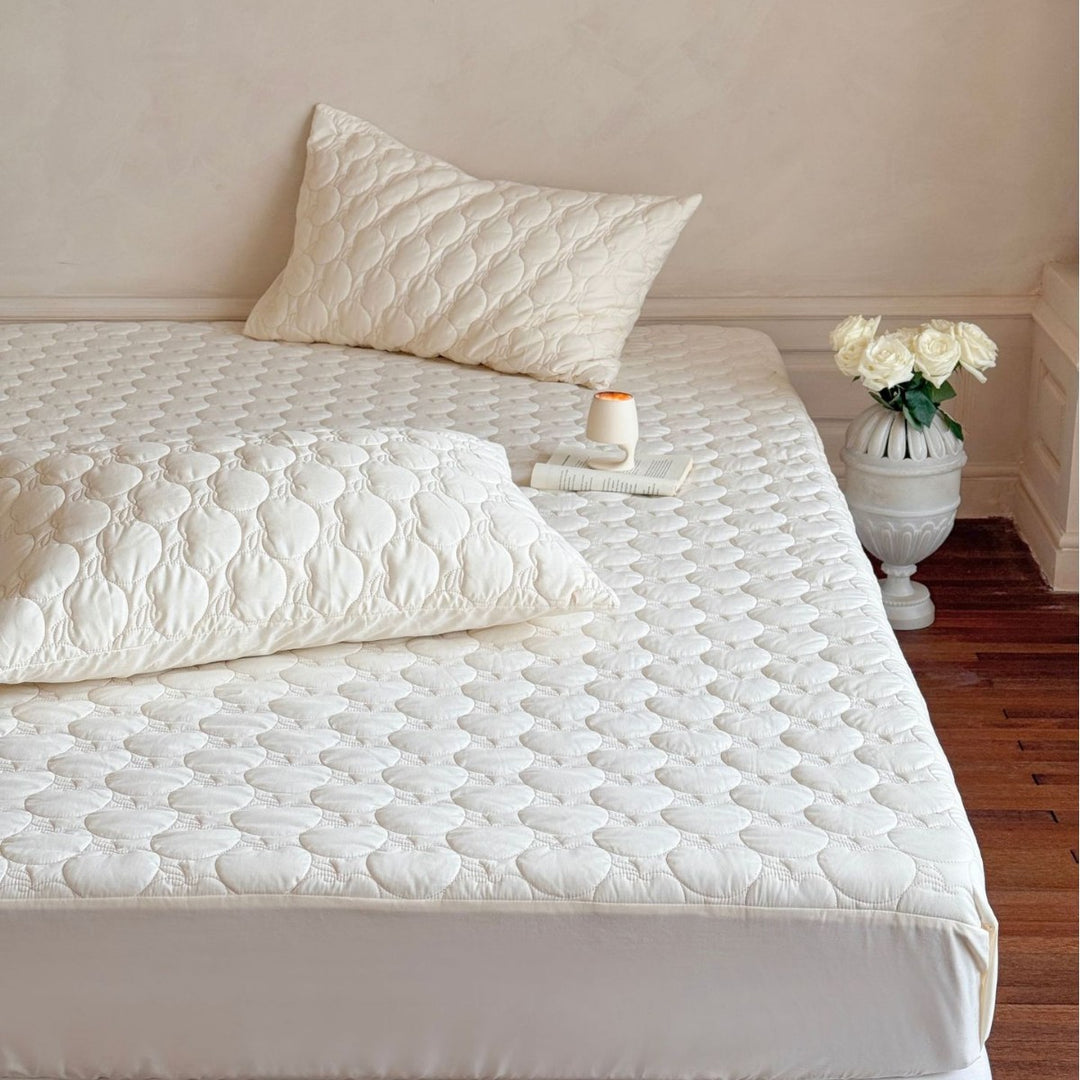 Padded mattress protector with quilted comfort layer and all-around elastic band