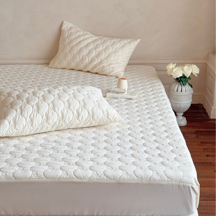 Padded mattress protector with quilted comfort layer and all-around elastic band
