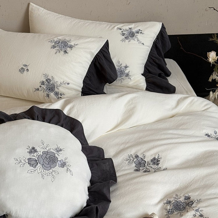Cotton muslin bedding set with embroidered rose emblems and fine ruffle