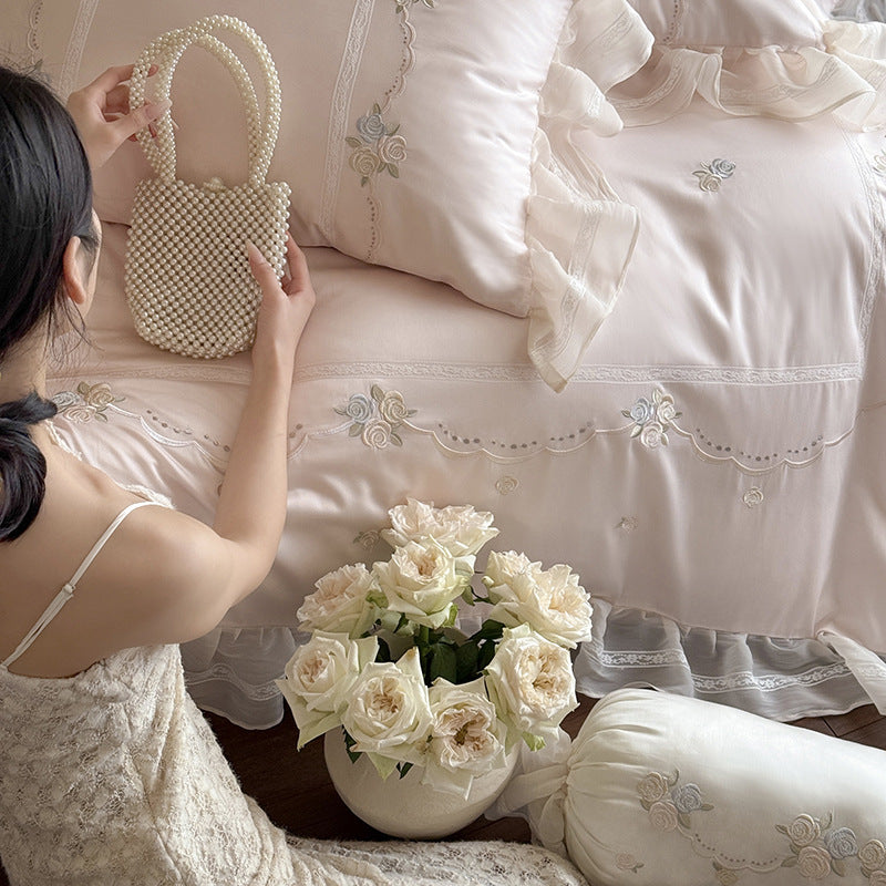Satin bedding set with fine ruffle trim, delicate floral embroidery, and decorative pillowcases