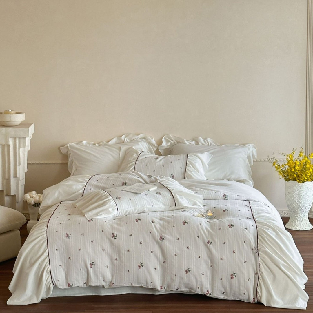 Romantic bed linen set made of cotton satin with ruffles, relief stripes, and contrasting piping