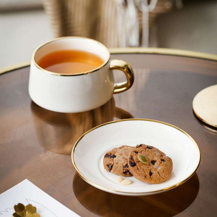 Elegant porcelain cup with saucer and sculptural gold handle