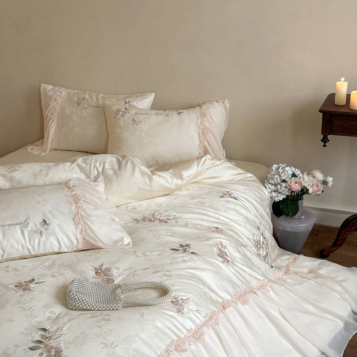 Romantic satin bedding set with embroidered floral design, ruffle and pillowcases