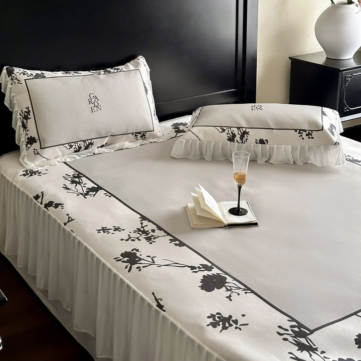 Bedding set with ruffled bed skirt, floral printed center piece and frill pillow
