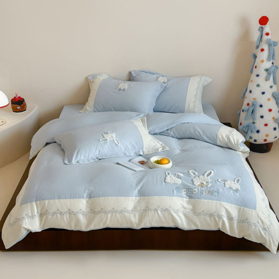 Embroidered cotton satin bedding set with appliquéd rabbit designs and decorative border