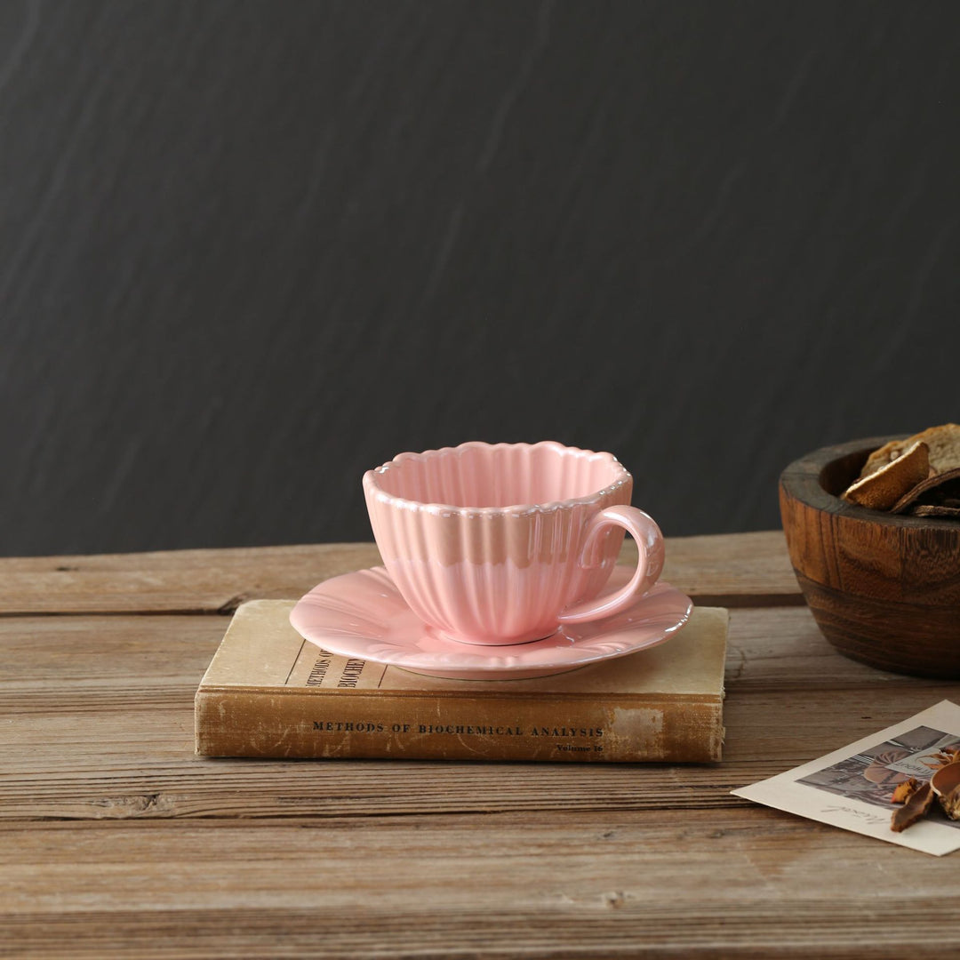 Fine porcelain tea cup with ribbed shell shape and matching saucer