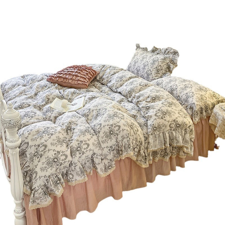 Romantic quilted comforter with ruffled border and fine floral pattern