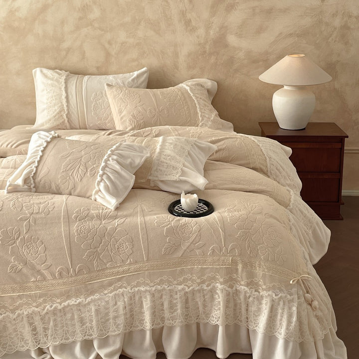 Luxury bedding set with quilted coverlet, lace ruffle, and decorative bed skirt