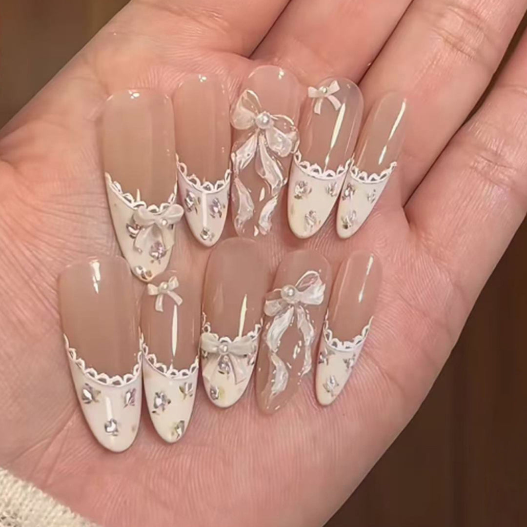 Artful nail art with elegant bows and rhinestone details Kalsten