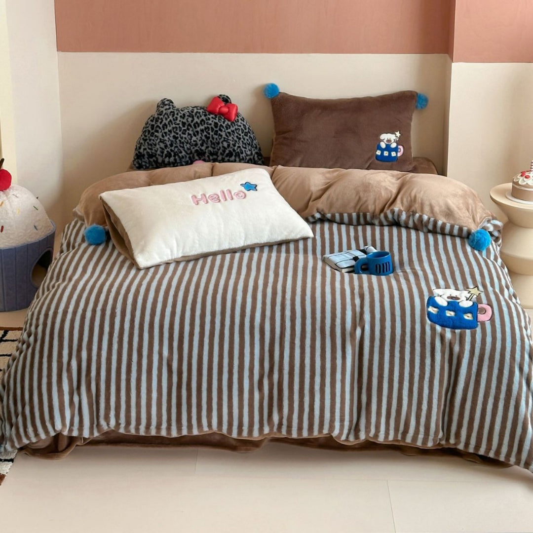 Striped plush throw blanket with decorative pom poms and appliqués