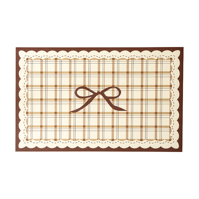 Rectangular table set placemat made of coated cotton mix with check pattern, decorative edge and bow motif