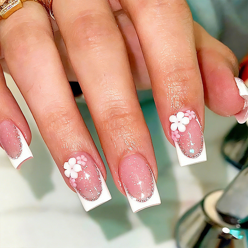 Acrylic nail set with elegant French tip and delicate floral decorations Kalsten