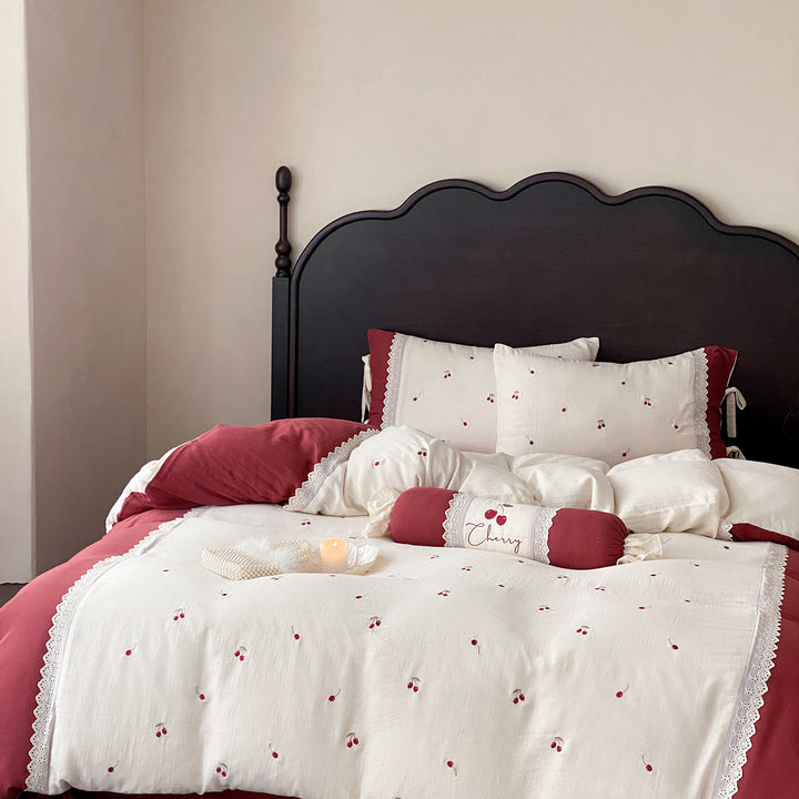 Country-style bedding set with cherry embroidery, lace trim, and decorative neck roll