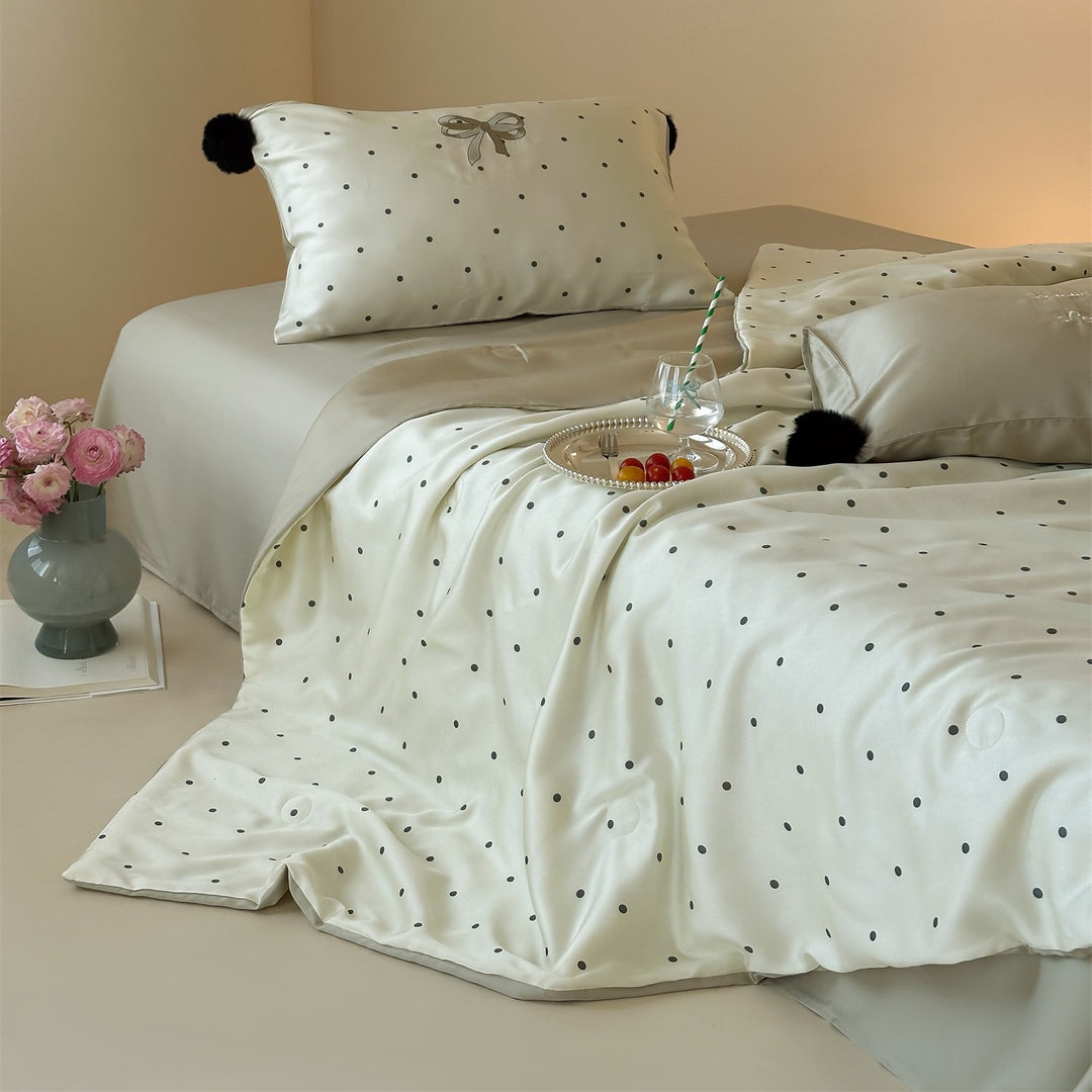 Luxurious satin bedding set with polka dot pattern and pom-pom tassels