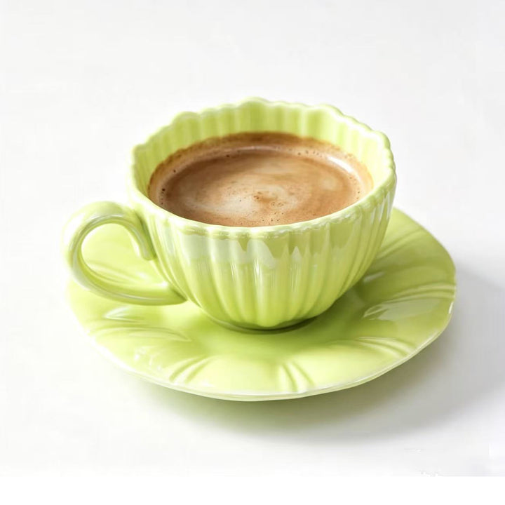 Fine porcelain tea cup with ribbed shell shape and matching saucer