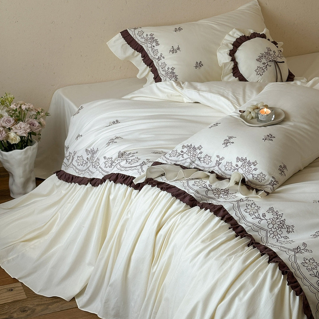 Luxurious bedding set with embroidered cover, ruffled bed skirt, and decorative pillow