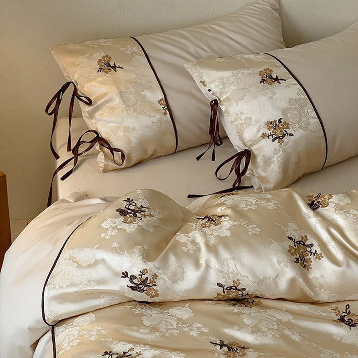 Satin bedding set in jacquard look with floral embroidery details and ribbon ties