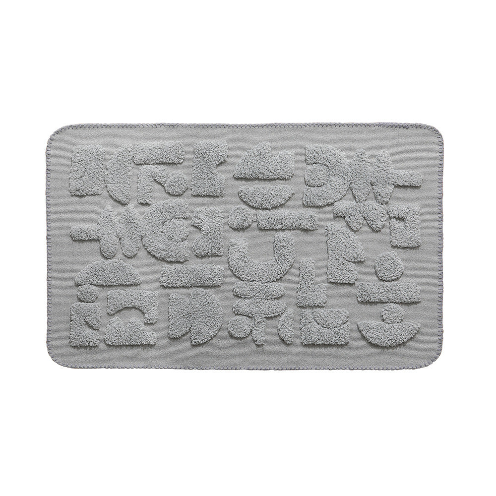 Rectangular cotton bath mat with abstract 3D tuft relief and non-slip back