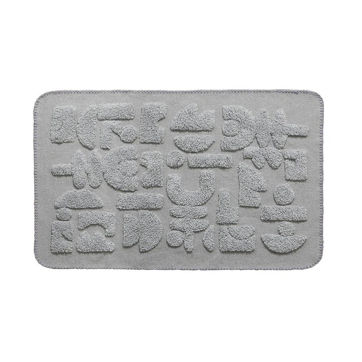 Rectangular cotton bath mat with abstract 3D tuft relief and non-slip back