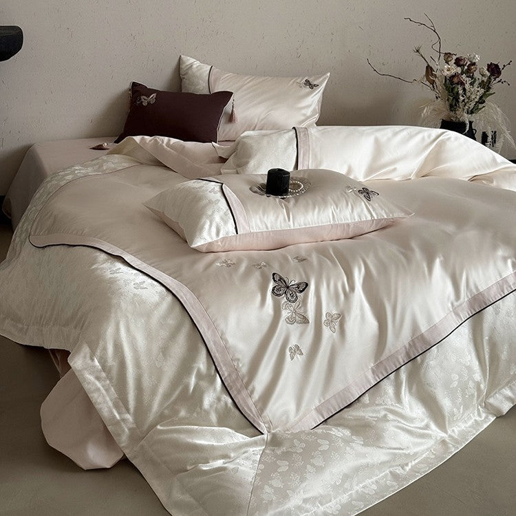 Luxurious satin bedding set with embroidered butterflies, decorative pillows, and tassels