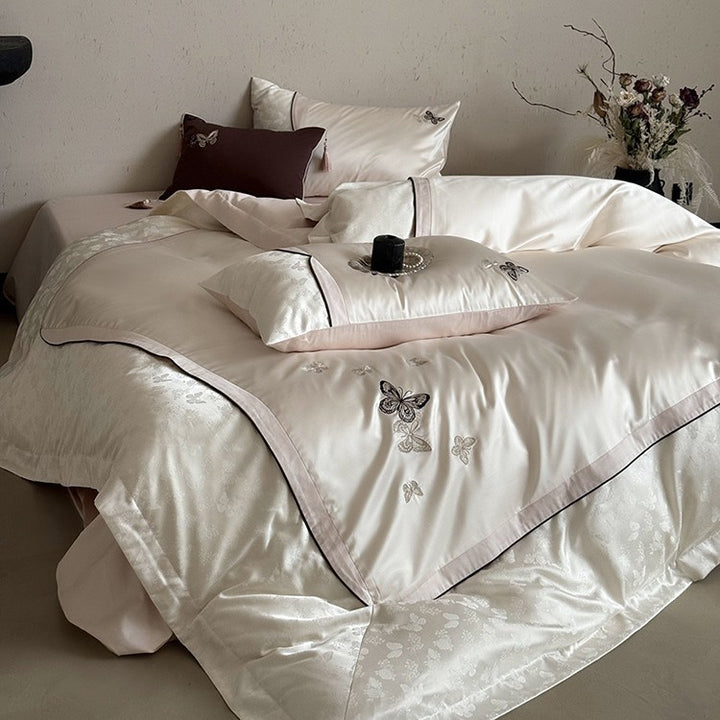 Luxurious satin bedding set with embroidered butterflies, decorative pillows, and tassels