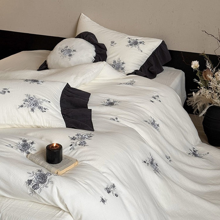 Cotton muslin bedding set with embroidered rose emblems and fine ruffle