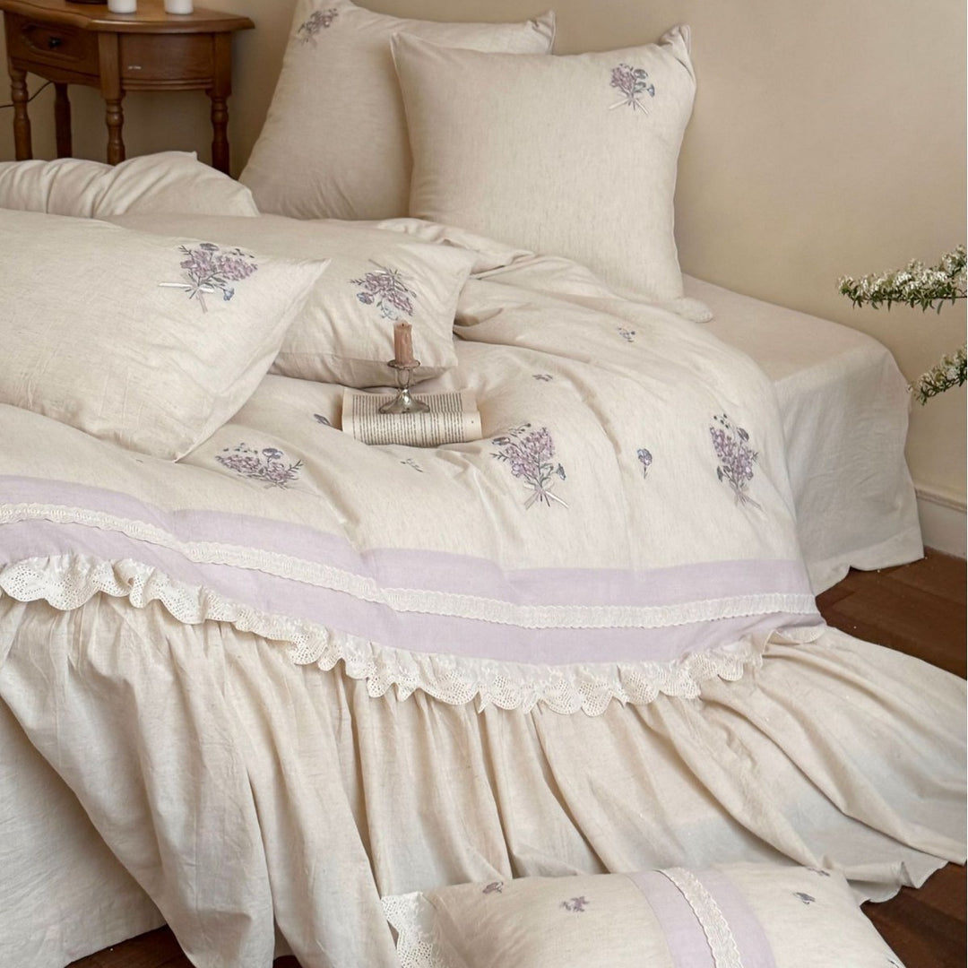 Vintage-inspired bedding set with ruffled bed skirt and delicate floral embroidery