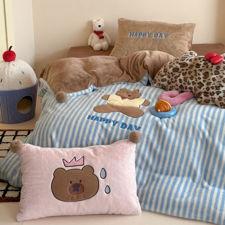 Striped plush throw blanket with decorative pom poms and appliqués