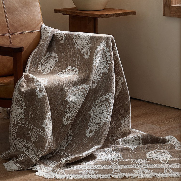 Large cozy living blanket made of cotton blend fabric with geometric jacquard pattern and fringed hem
