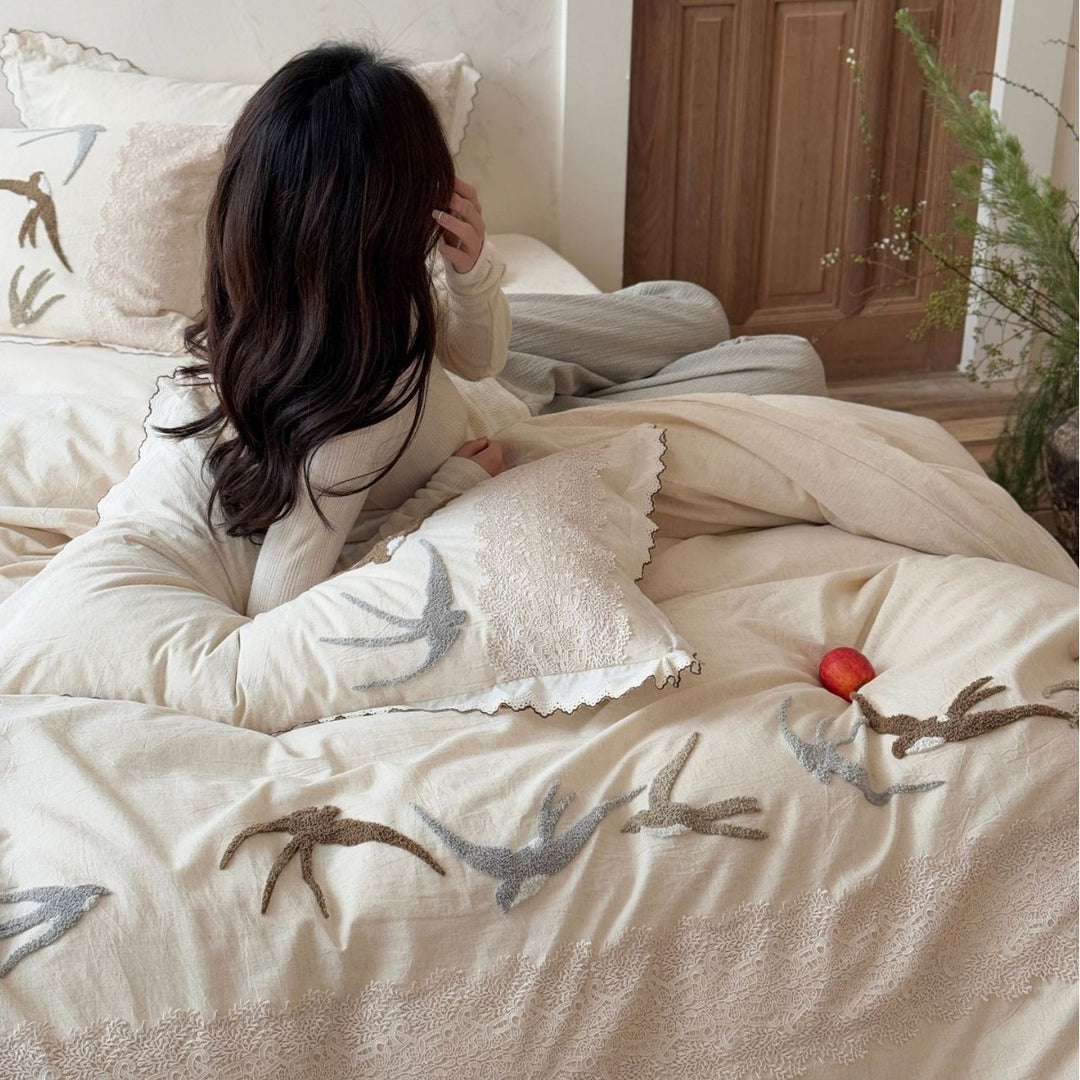Home decor bedding set made of organic linen with hand-embroidered swallow motif and wavy hem