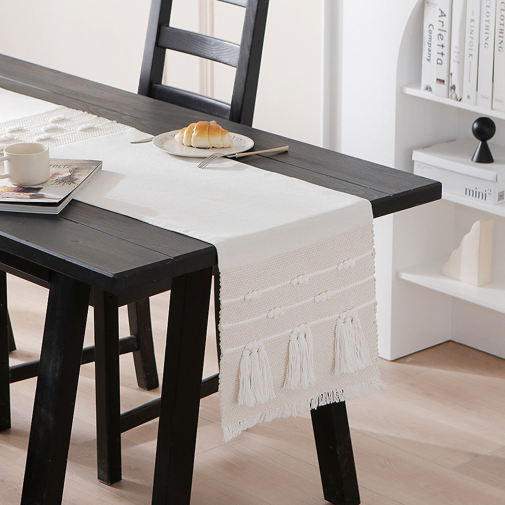 Woven decorative table runner with textured fringes and tactile weaving pattern