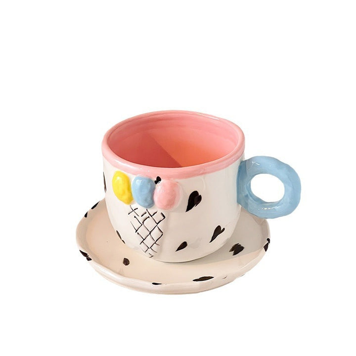 Playful handcrafted ceramic cup composition with saucer and pastel-colored round handle