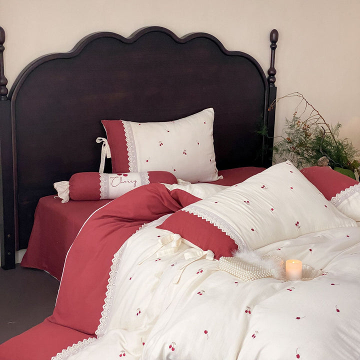 Country-style bedding set with cherry embroidery, lace trim, and decorative neck roll
