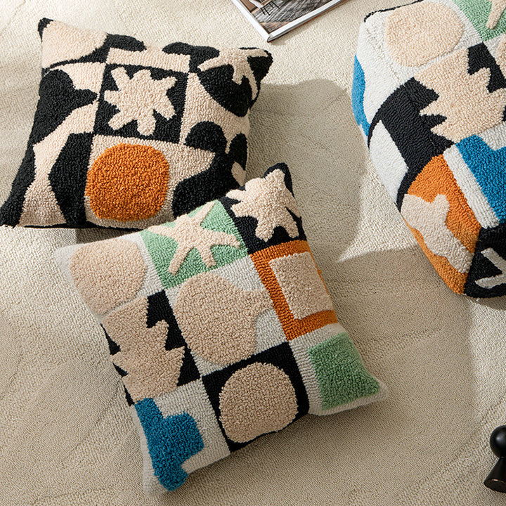 Hand-tufted decorative cushion with abstract graphic design and textured cotton surface