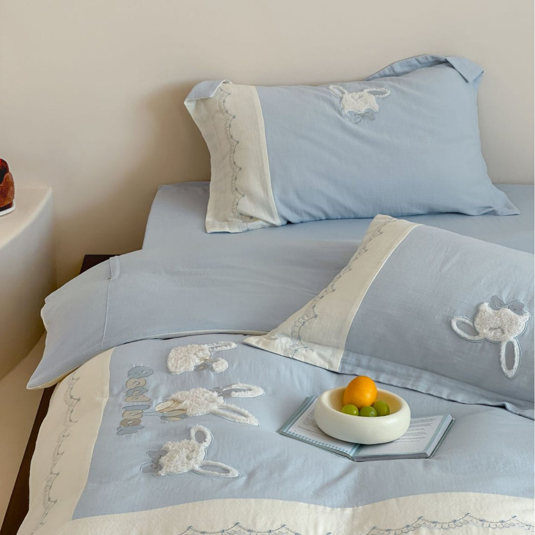 Embroidered cotton satin bedding set with appliquéd rabbit designs and decorative border