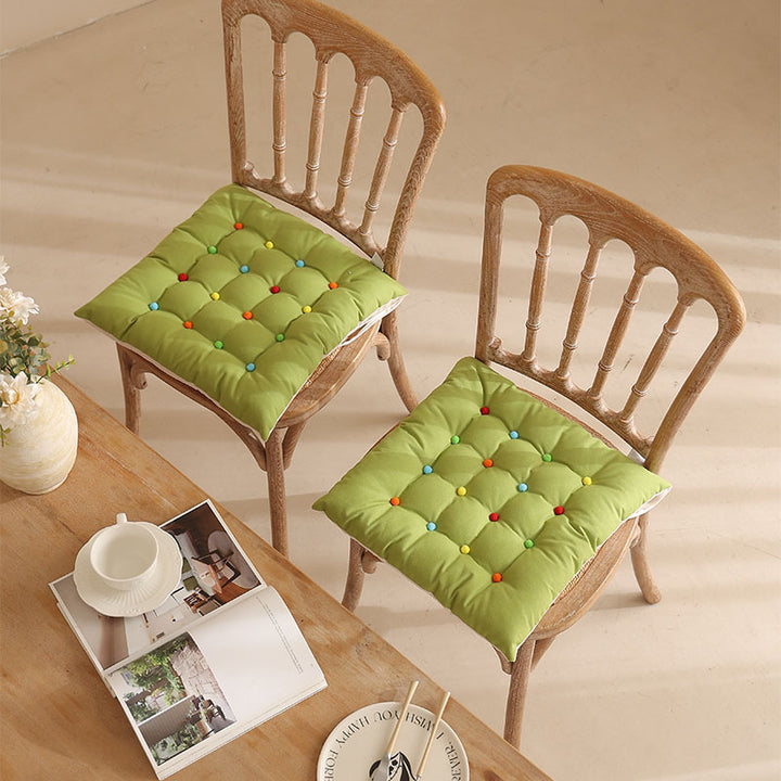 Padded quilted seat cushion with colorful button applications and non-slip underside Kalsten