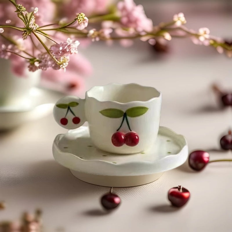 Hand-shaped espresso cup with wavy edge, round handle plate and applied cherry relief