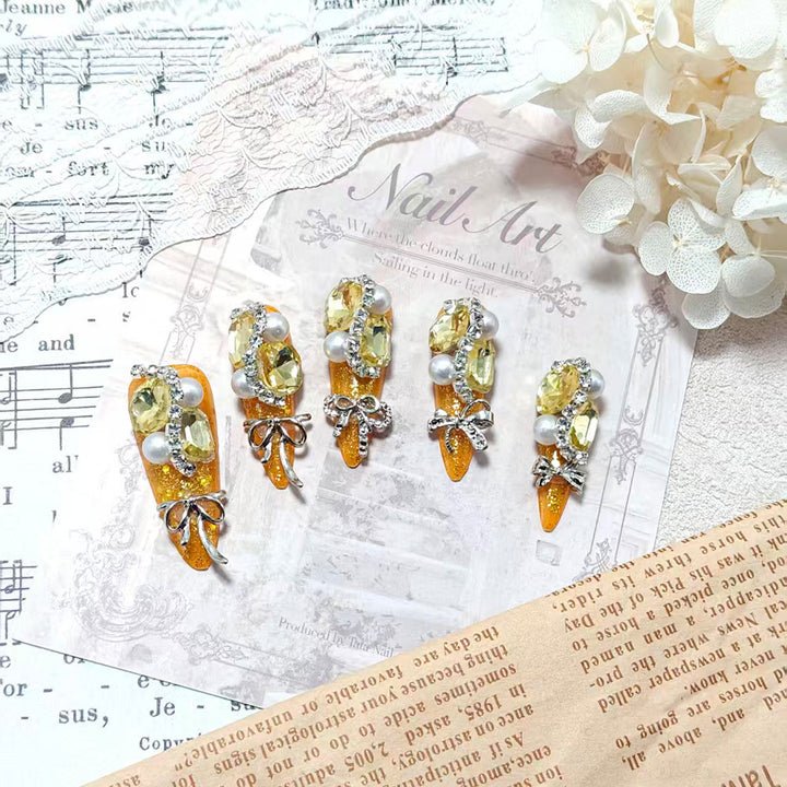 Glamorous artificial nails with rhinestones and pearl embellishments Kalsten
